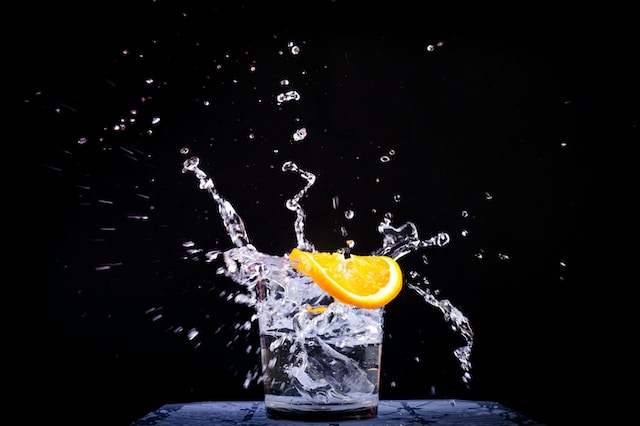 cup full of water with an orange piece